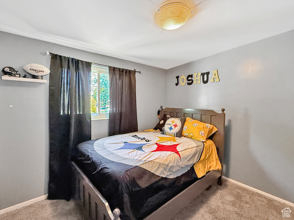 Bedroom featuring carpet floors and baseboards