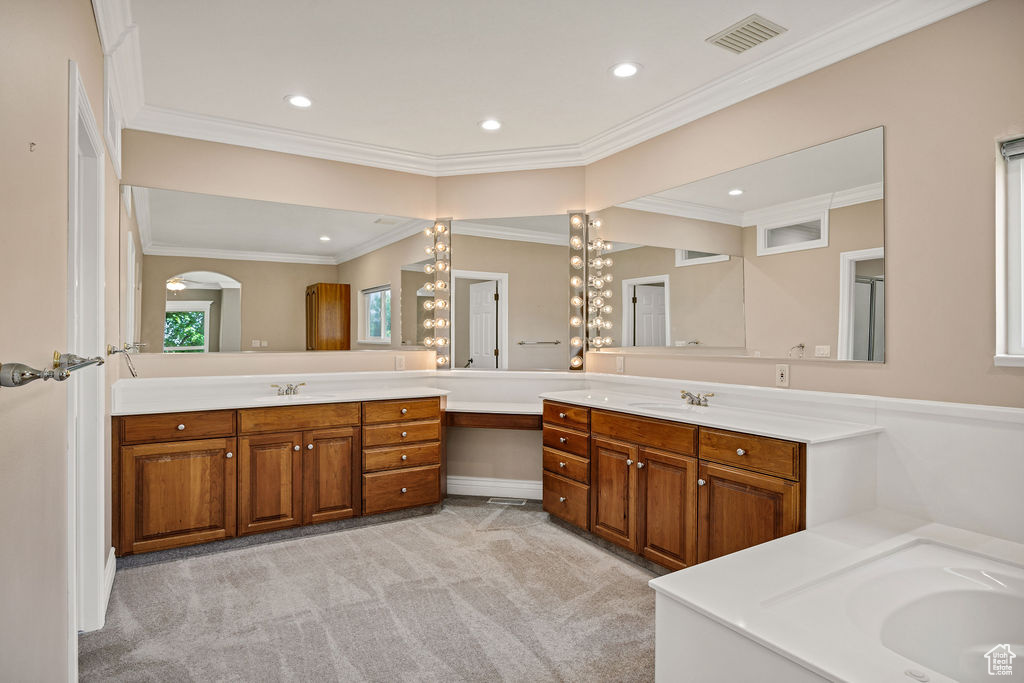 Bathroom with vanity, recessed lighting, crown molding, and a bathtub