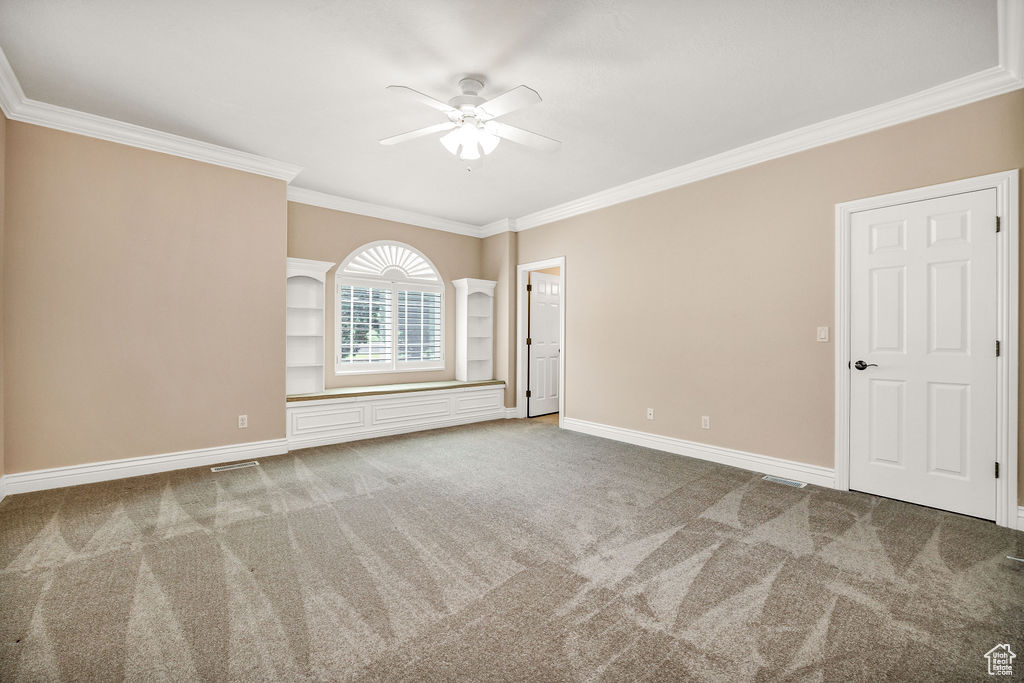 Unfurnished room with ceiling fan, crown molding, carpet flooring, and baseboards