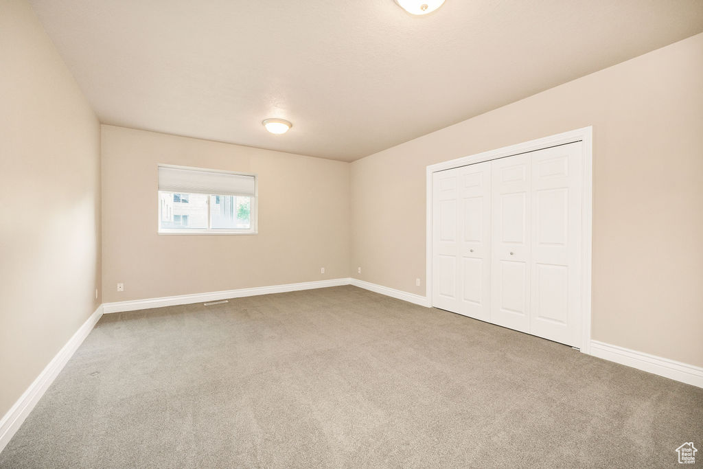 Unfurnished bedroom with carpet flooring, baseboards, and a closet