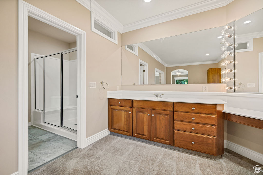 Bathroom featuring vanity, ornamental molding, a shower stall, baseboards, and recessed lighting
