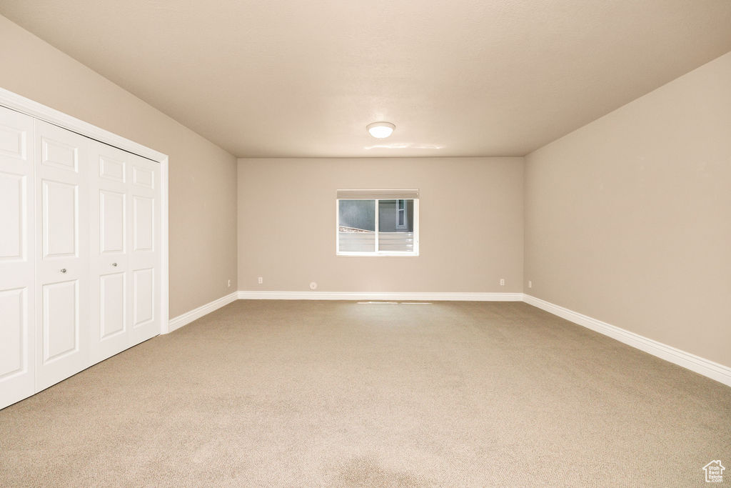 Unfurnished bedroom featuring carpet, baseboards, and a closet