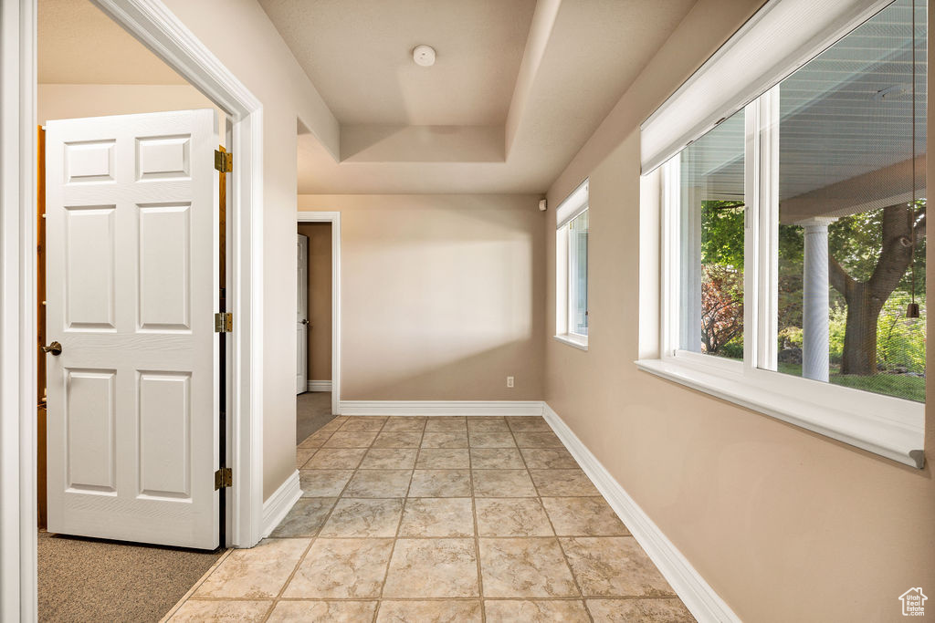 Hall featuring baseboards and a raised ceiling
