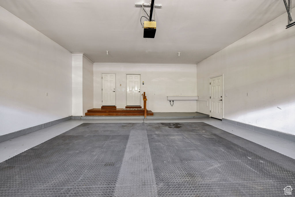 Garage with a garage door opener and baseboards