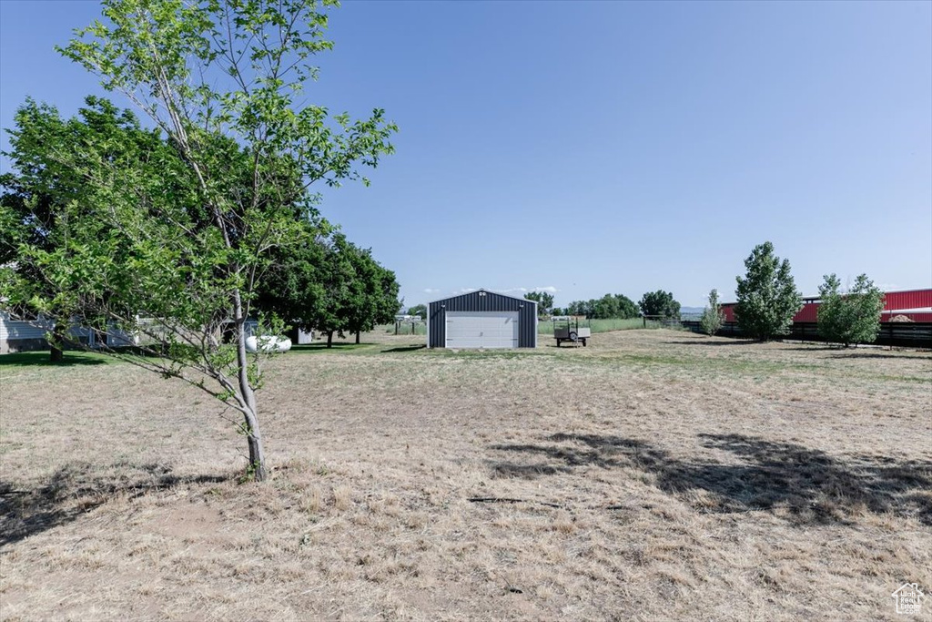 View of yard featuring a detached garage and an outbuilding
