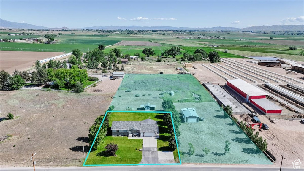 Aerial view of sparsely populated area with property parcel outlined and a mountain backdrop