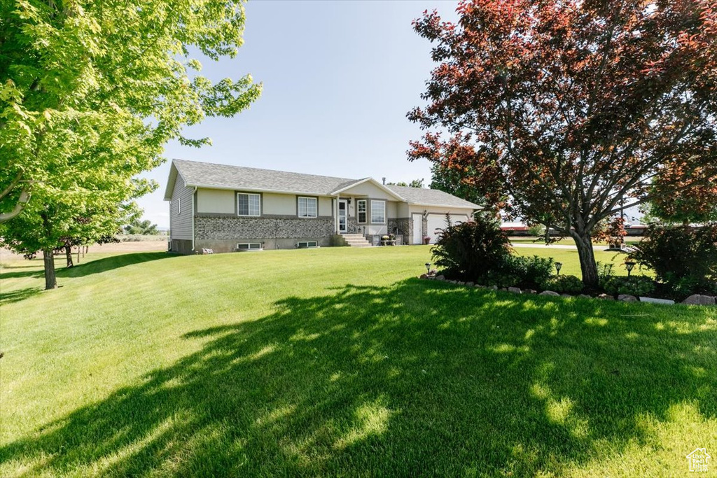 Ranch-style home with an attached garage and a front lawn