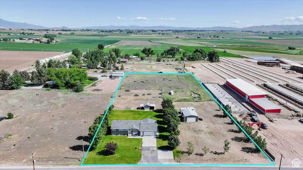 Aerial view of sparsely populated area featuring property parcel outlined and a mountainous background