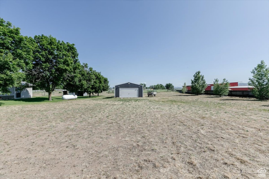 View of yard with a detached garage and an outdoor structure
