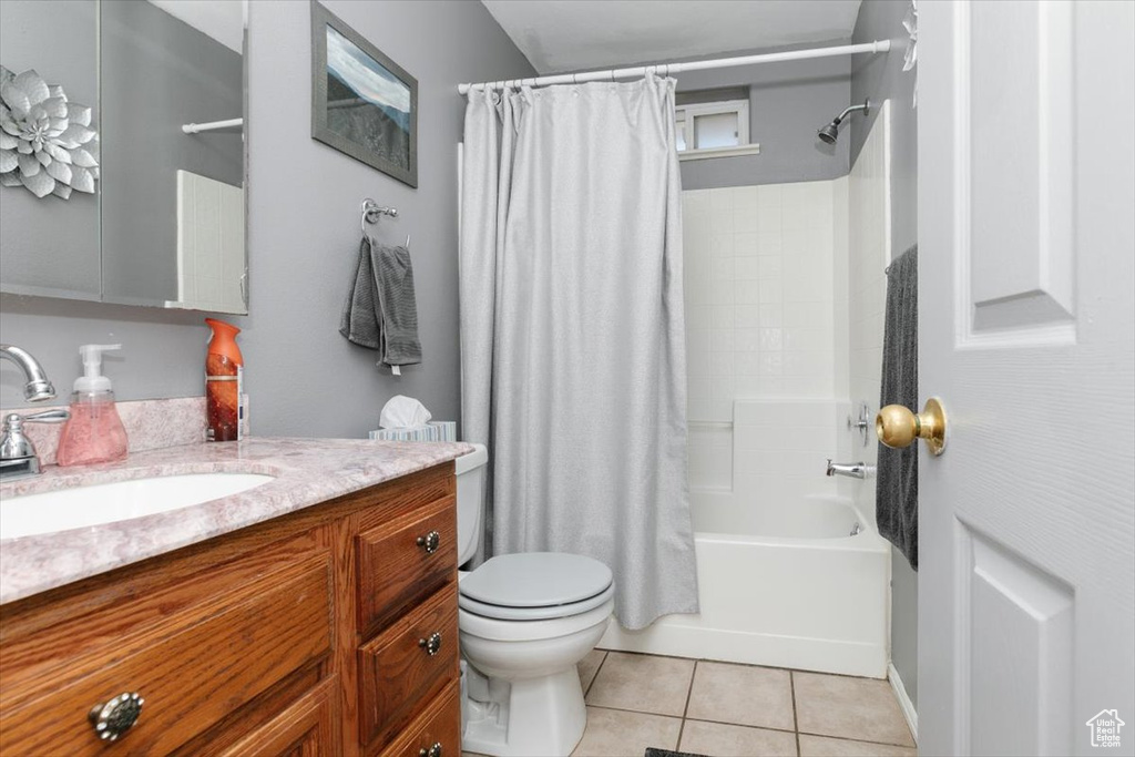 Full bathroom featuring toilet, vanity, shower / bath combo, and tile patterned floors