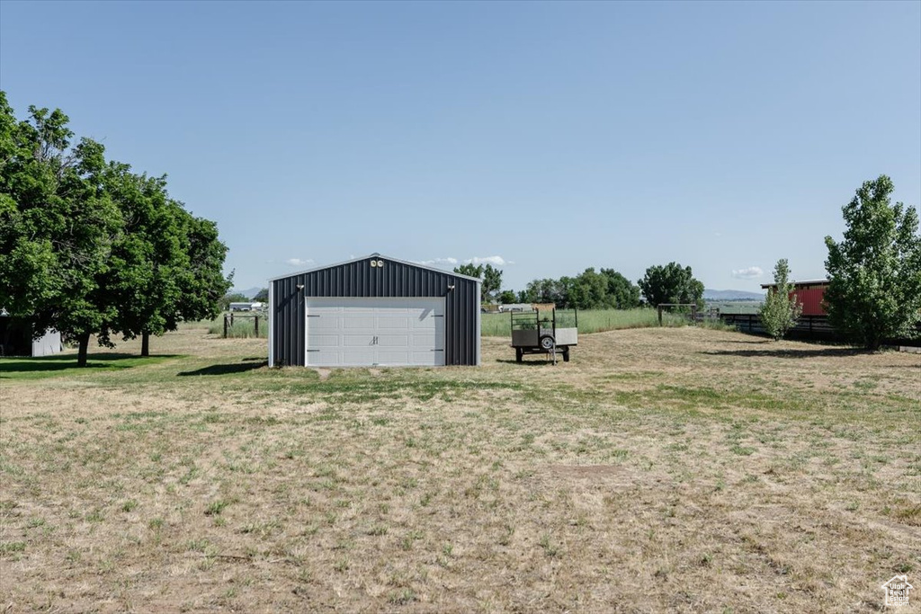 View of yard with a garage and an outbuilding
