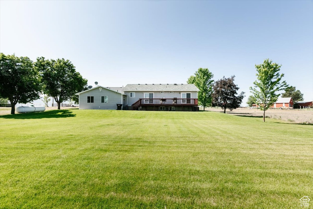 View of green lawn with a wooden deck
