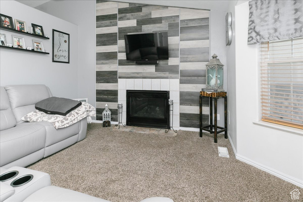 Living area featuring an accent wall, carpet floors, baseboards, and a large fireplace