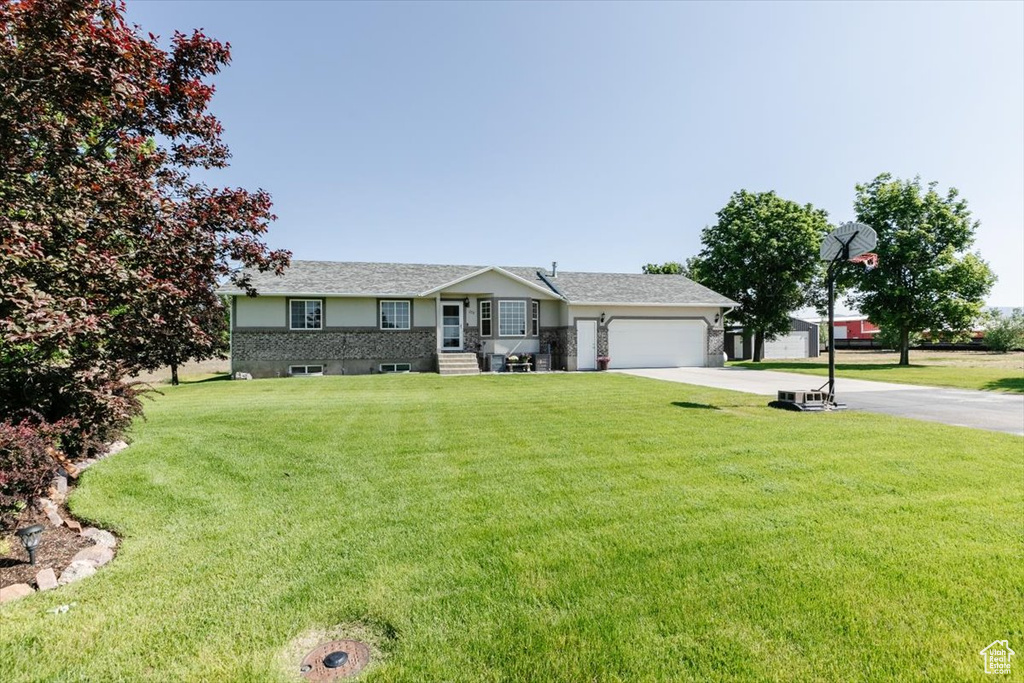 Single story home with concrete driveway, a garage, and a front yard
