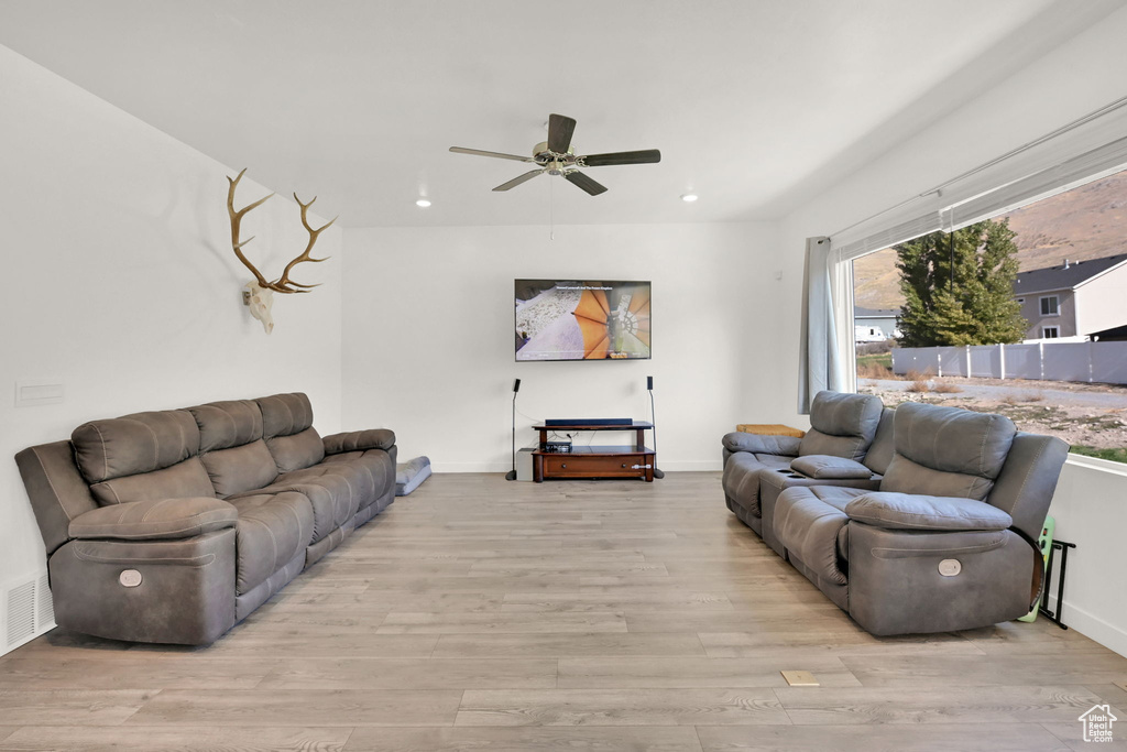 Living area featuring wood finished floors, a ceiling fan, recessed lighting, and baseboards