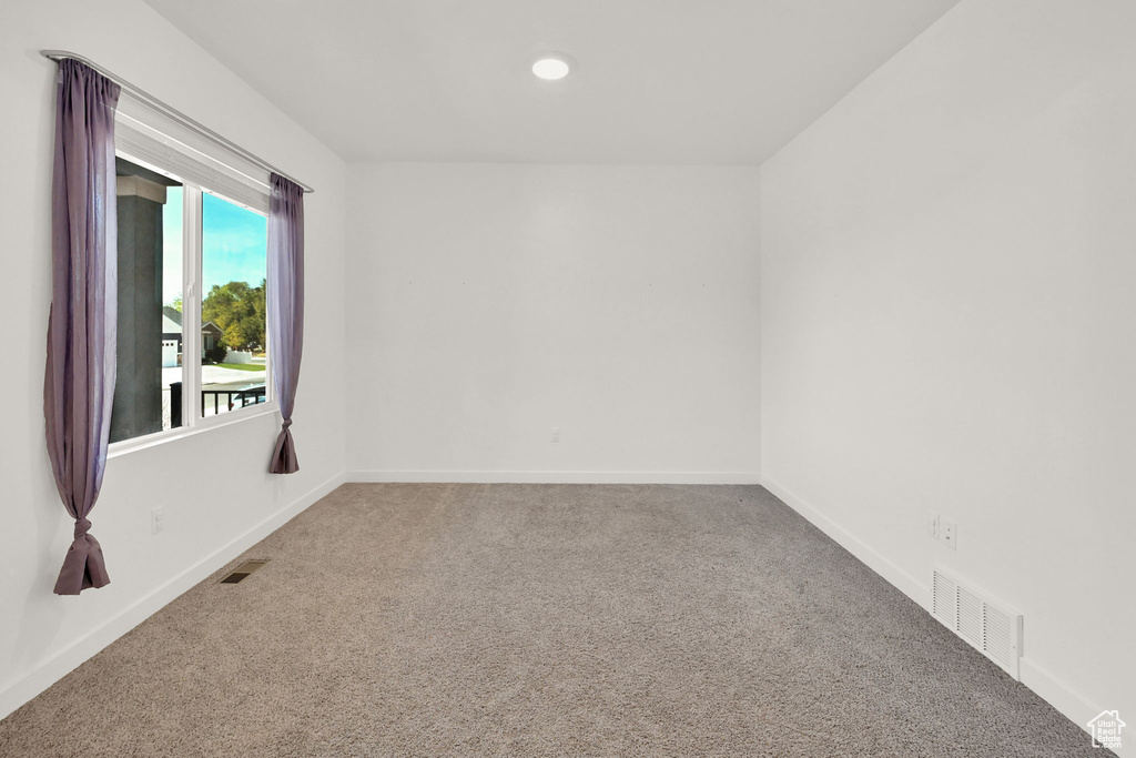 Carpeted empty room with baseboards and recessed lighting