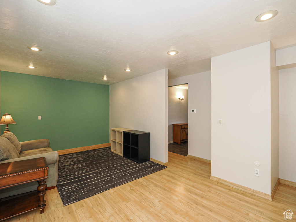 Living area with light wood-type flooring, baseboards, and recessed lighting
