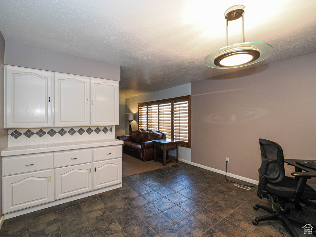 Office space featuring baseboards and a textured ceiling