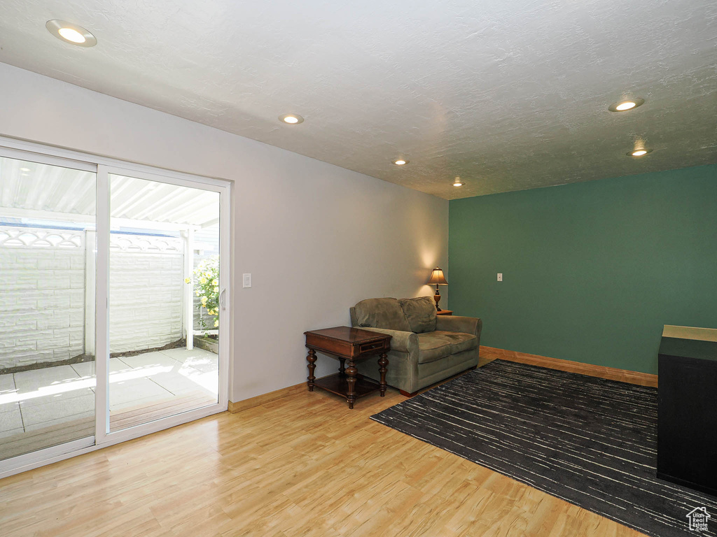 Living area with wood finished floors, recessed lighting, and baseboards