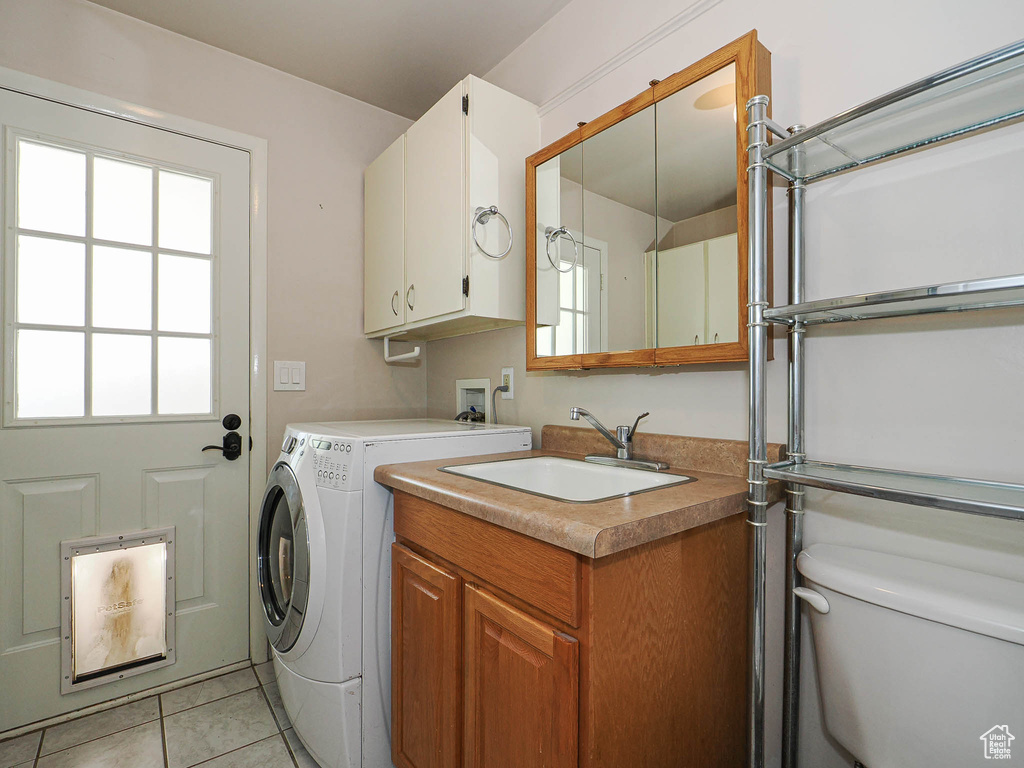 Laundry area featuring a sink, light tile patterned flooring, and washer and dryer