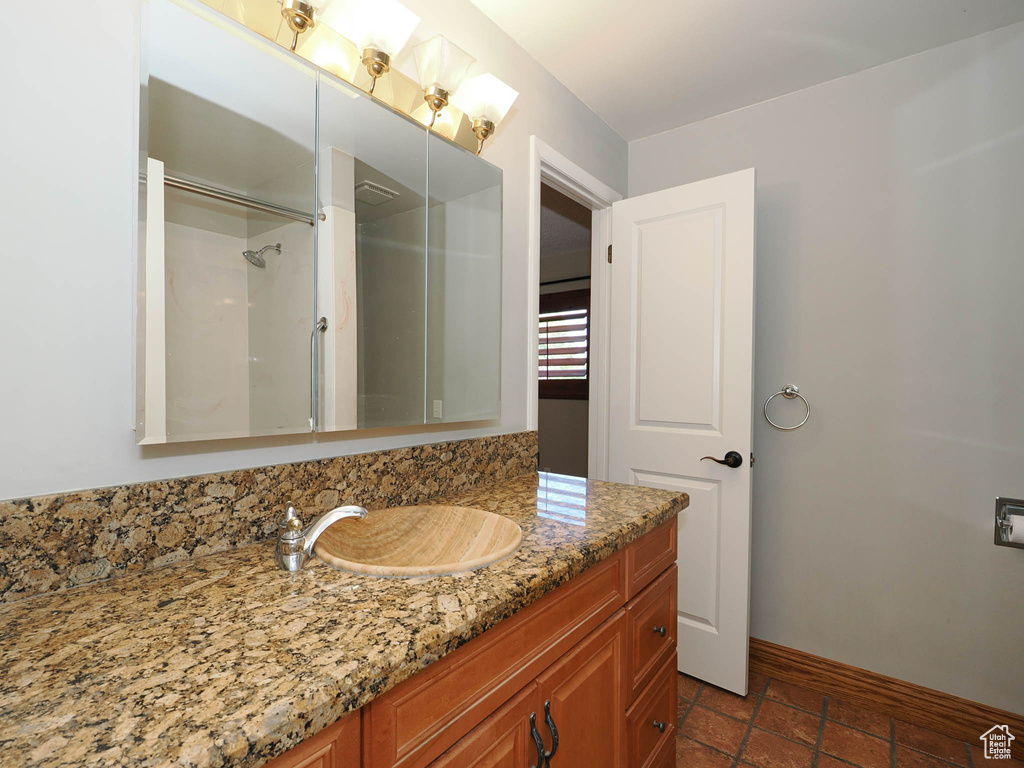 Bathroom with vanity, baseboards, and a shower