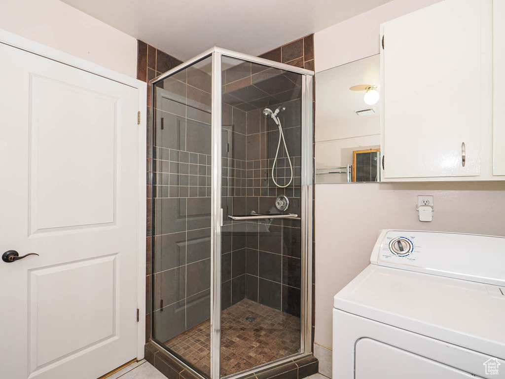 Bathroom with washer / clothes dryer and a shower stall