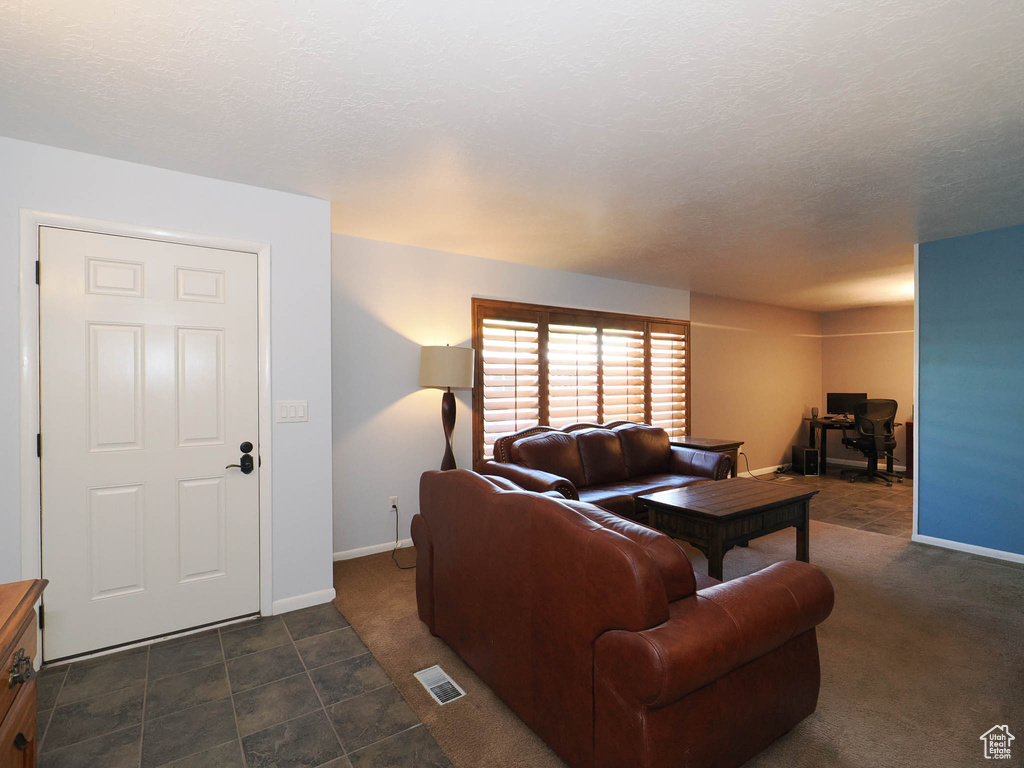 Living room featuring baseboards and dark carpet