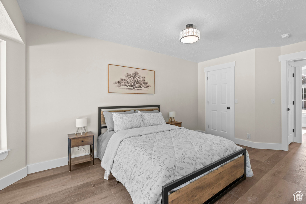 Bedroom with wood finished floors and baseboards