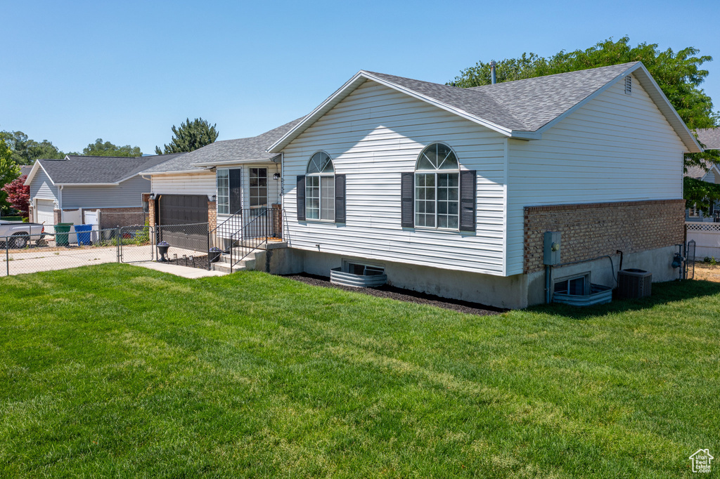 Rear view of house featuring an attached garage, a shingled roof, concrete driveway, and brick siding