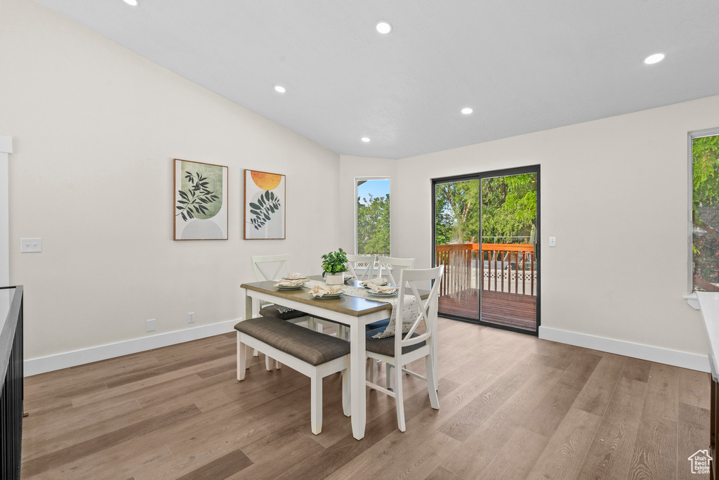 Dining area featuring plenty of natural light, recessed lighting, light wood-style flooring, baseboards, and vaulted ceiling