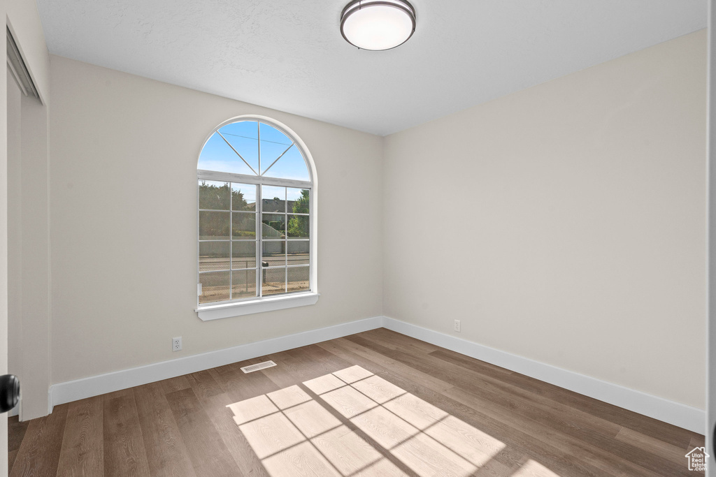 Empty room featuring wood finished floors and baseboards