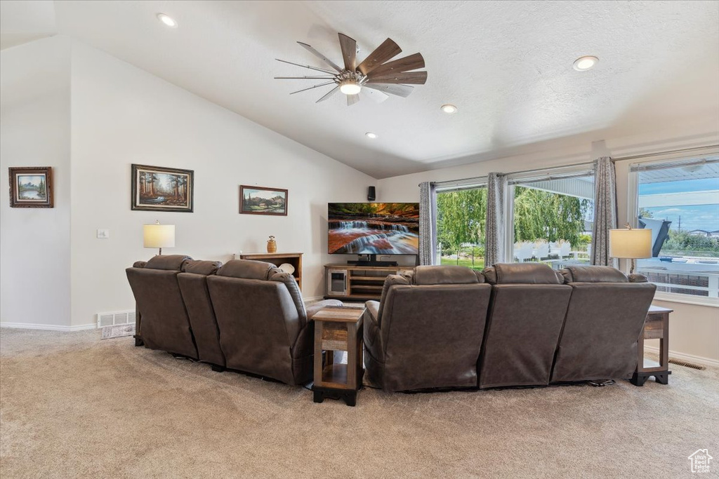 Living room featuring a ceiling fan, light colored carpet, plenty of natural light, vaulted ceiling, and recessed lighting
