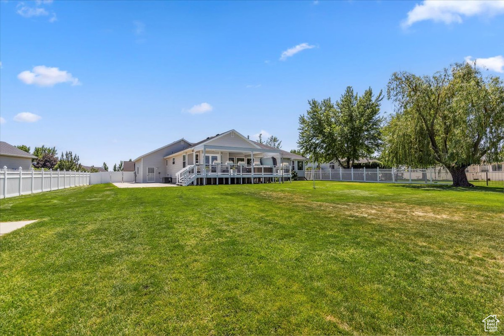 Rear view of property featuring a wooden deck and a patio