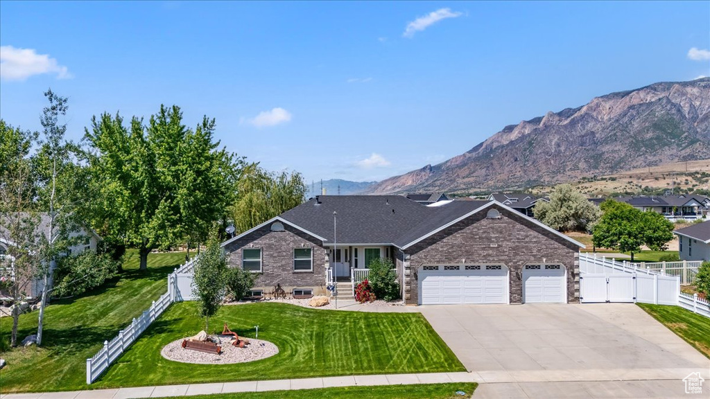 View of front facade featuring an attached garage, concrete driveway, a gate, and a mountain view