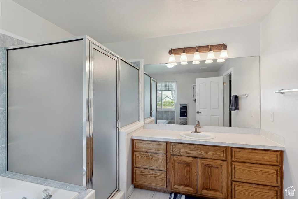 Bathroom featuring vanity, a stall shower, and a bath