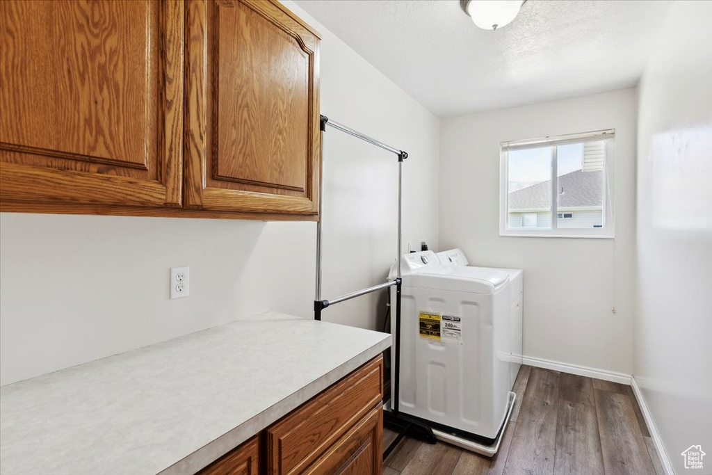 Laundry area featuring cabinet space, dark wood finished floors, baseboards, and independent washer and dryer