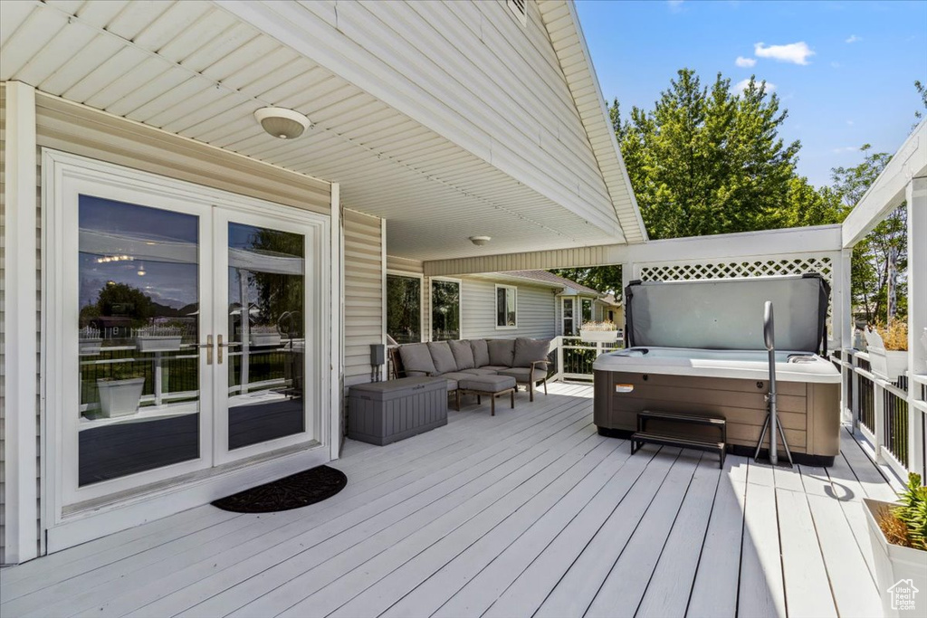 Wooden terrace with a hot tub, french doors, and an outdoor hangout area