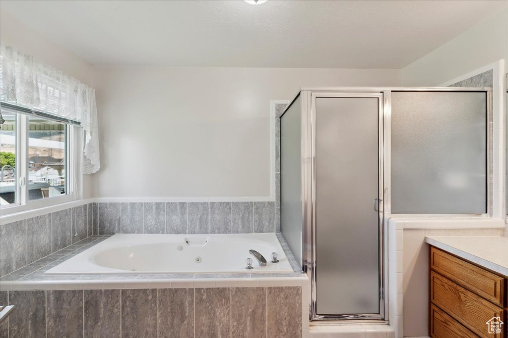 Full bathroom with a whirlpool tub, a shower stall, and vanity