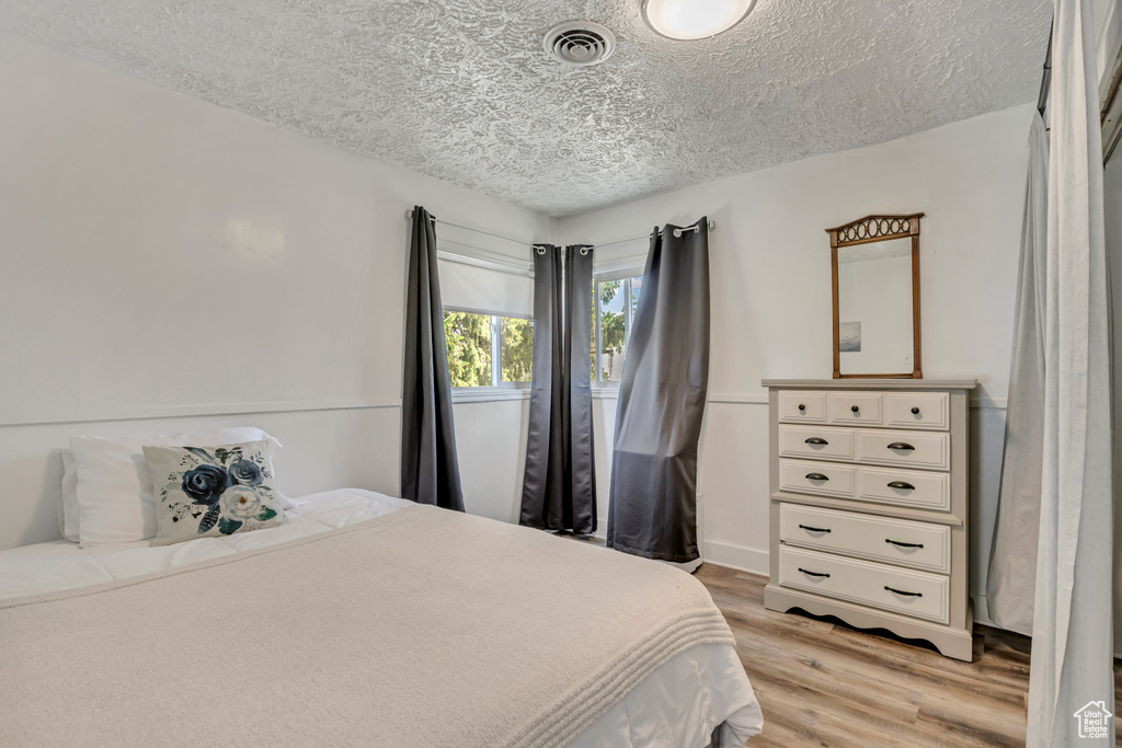 Bedroom featuring a textured ceiling and light wood finished floors