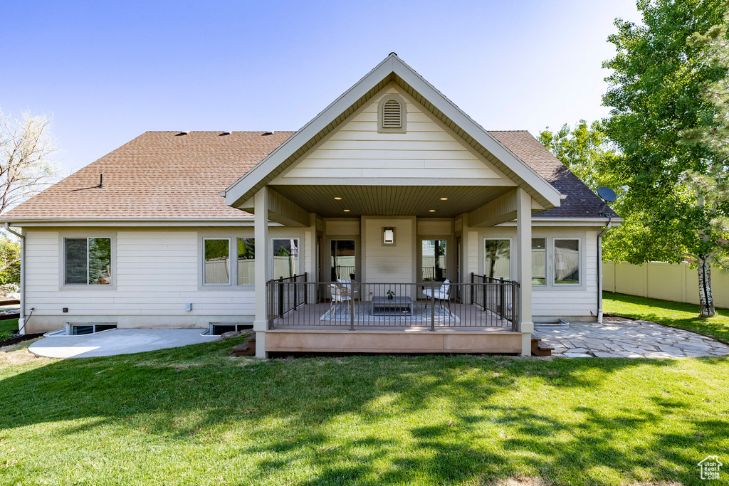 Back of house with roof with shingles, a patio, and a deck