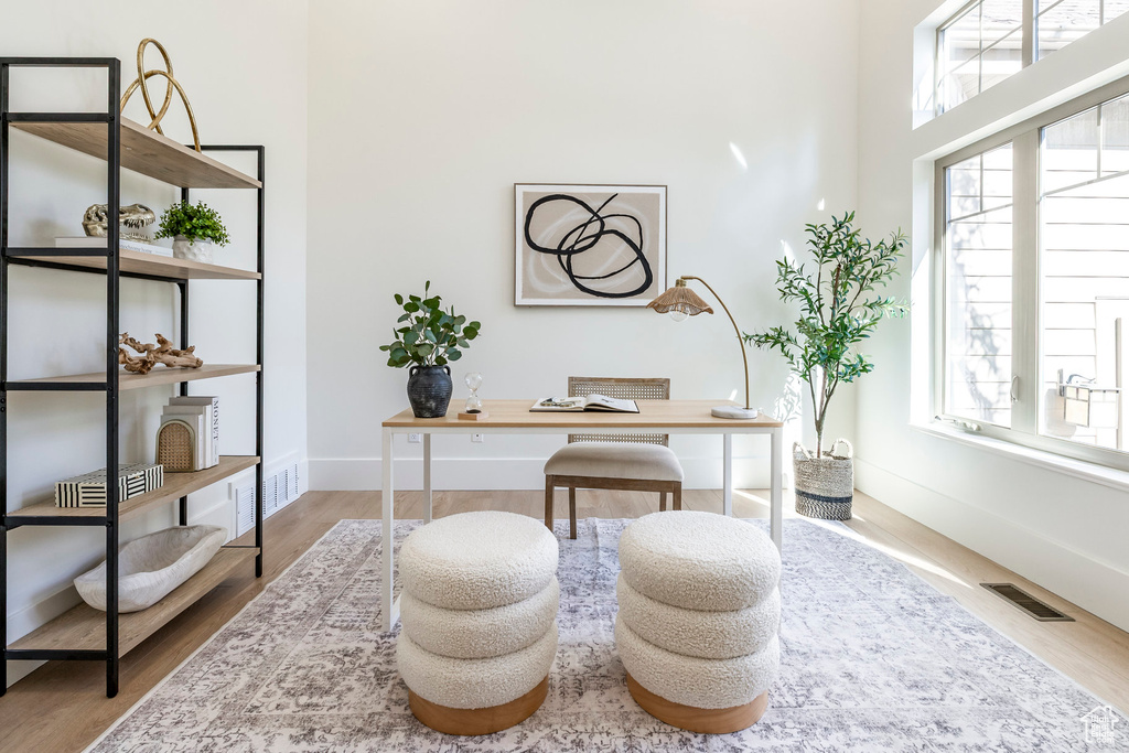 Home office featuring plenty of natural light, wood finished floors, and baseboards