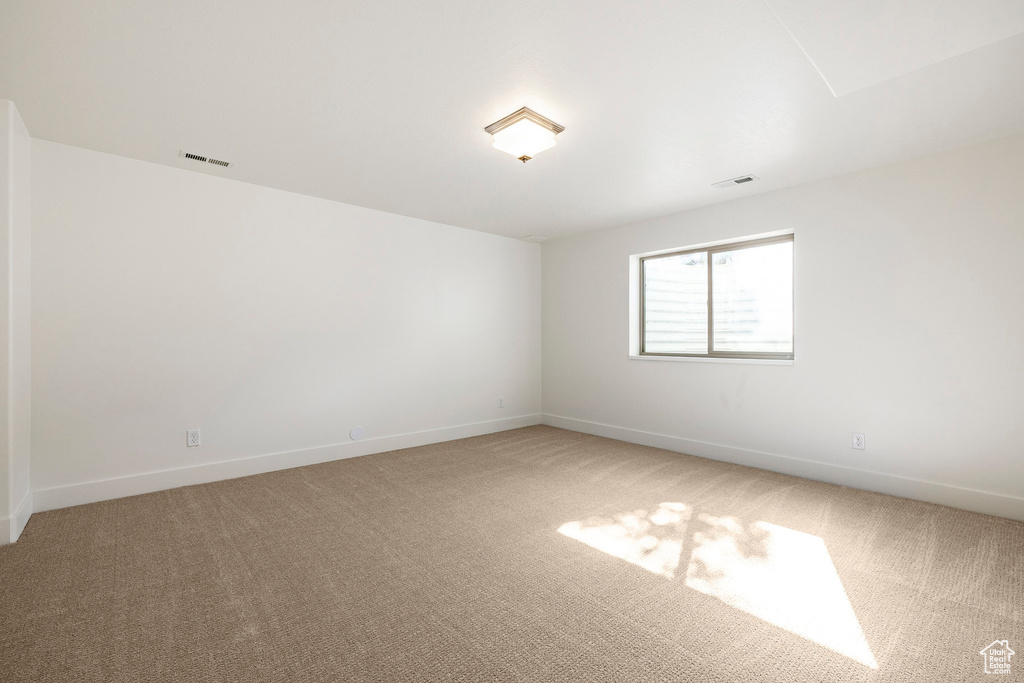 Empty room featuring light carpet and baseboards