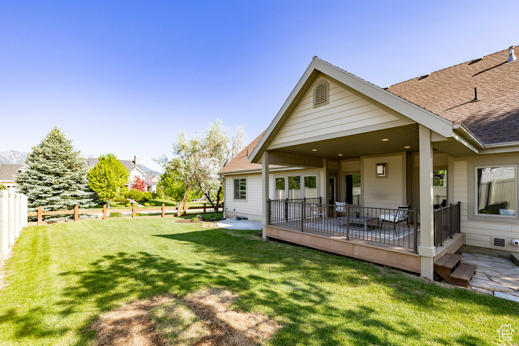 Rear view of property featuring roof with shingles and a patio