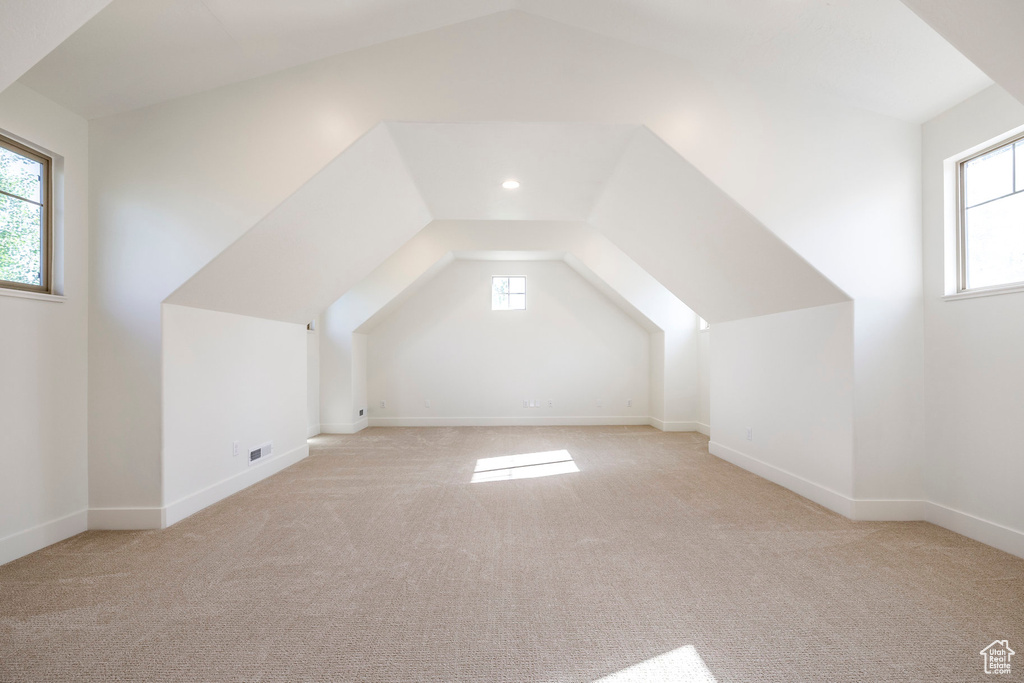Additional living space with carpet flooring, plenty of natural light, lofted ceiling, and recessed lighting