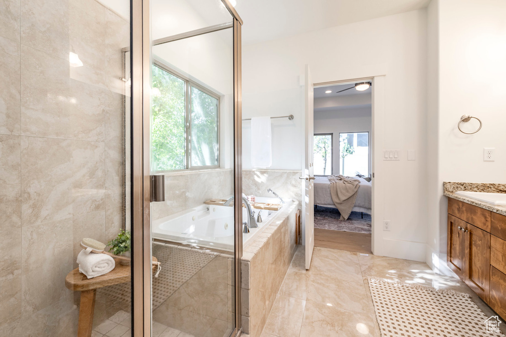 Ensuite bathroom featuring vanity, a garden tub, and a stall shower