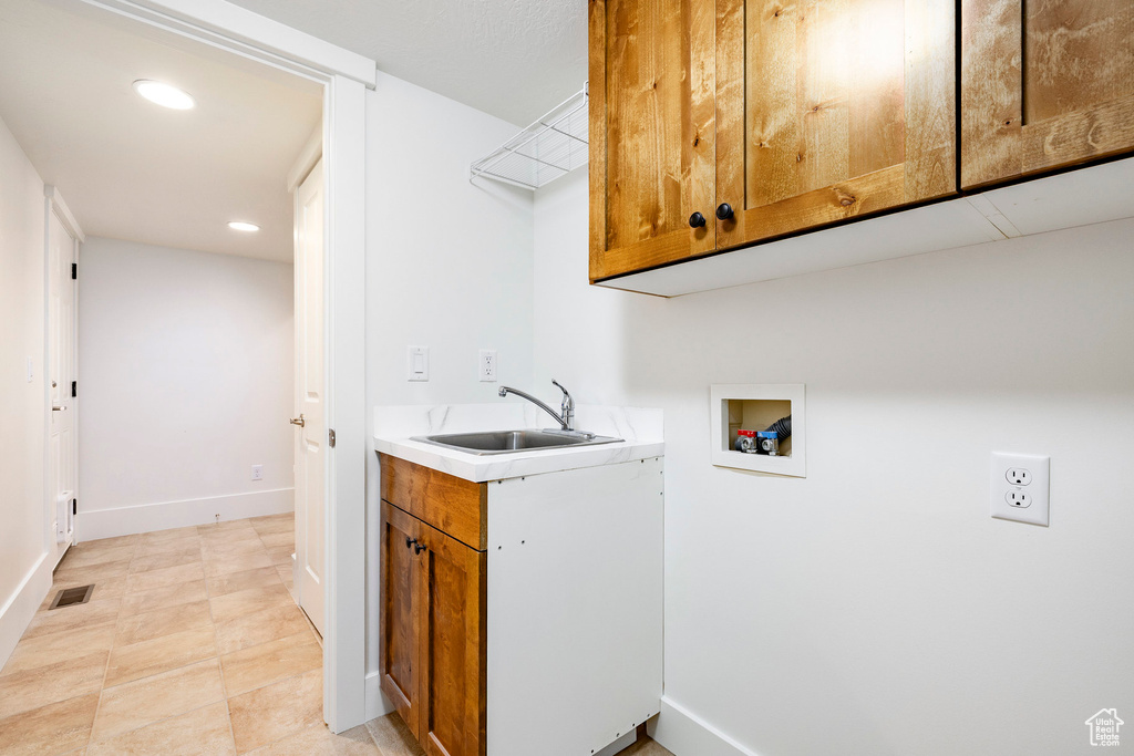 Washroom with hookup for a washing machine, cabinet space, baseboards, and recessed lighting