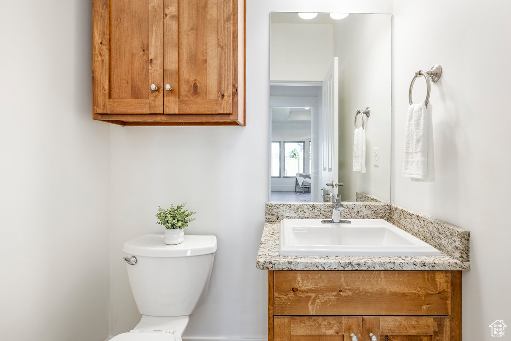Half bathroom featuring vanity and toilet