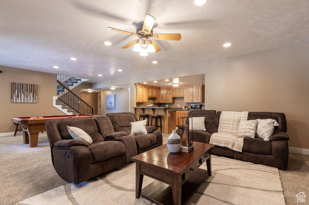 Living room featuring light colored carpet, baseboards, a ceiling fan, and recessed lighting