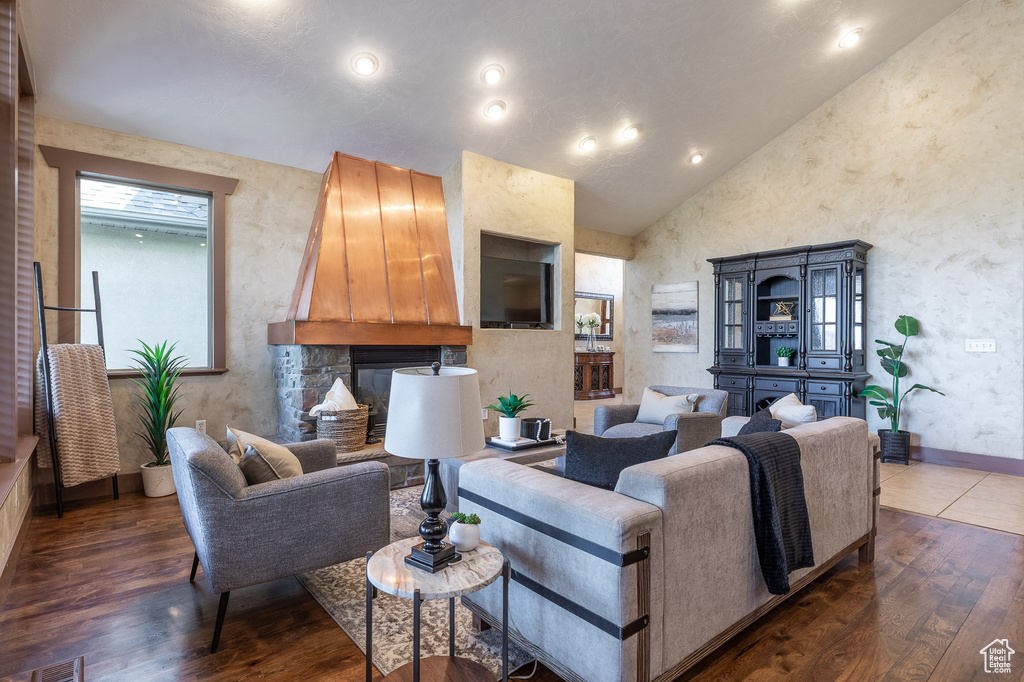 Living area featuring wood finished floors, baseboards, and high vaulted ceiling