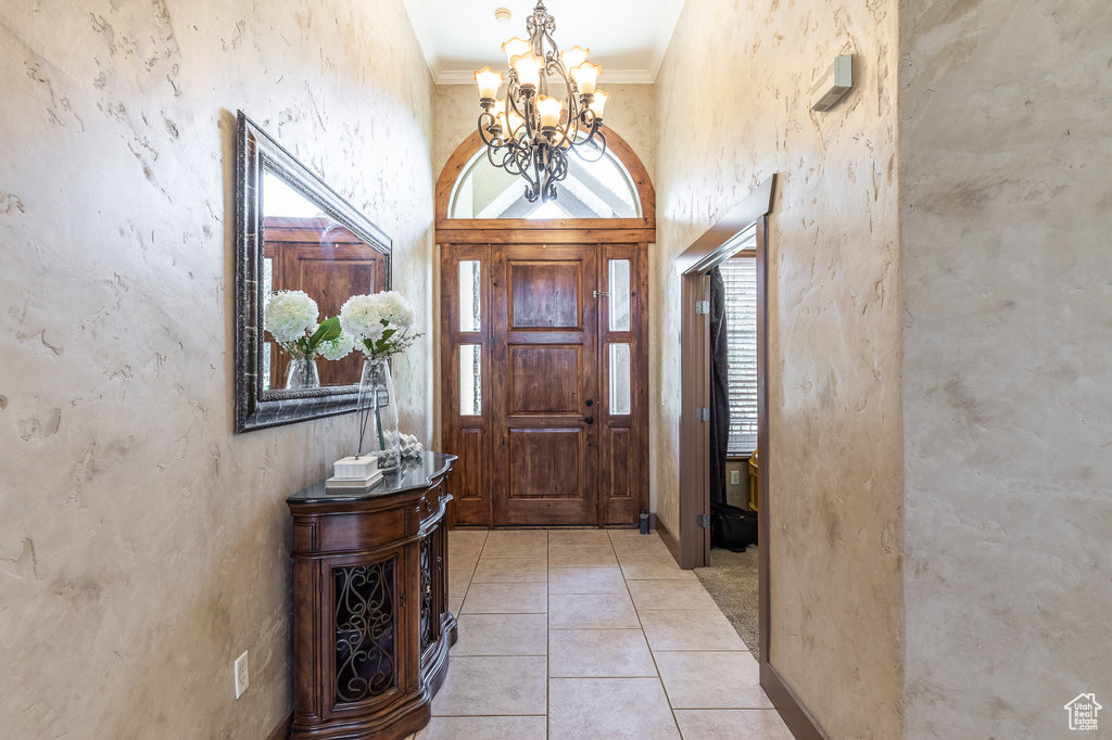 Entryway featuring a chandelier and crown molding